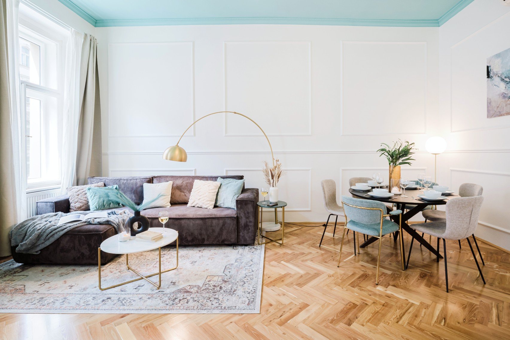 Įgyvendinimas: spalviškai išryškintos lubos, natūrali šviesa ir sluoksniuotos tekstūros suteikia interjerui lengvumo ir jaukumo.