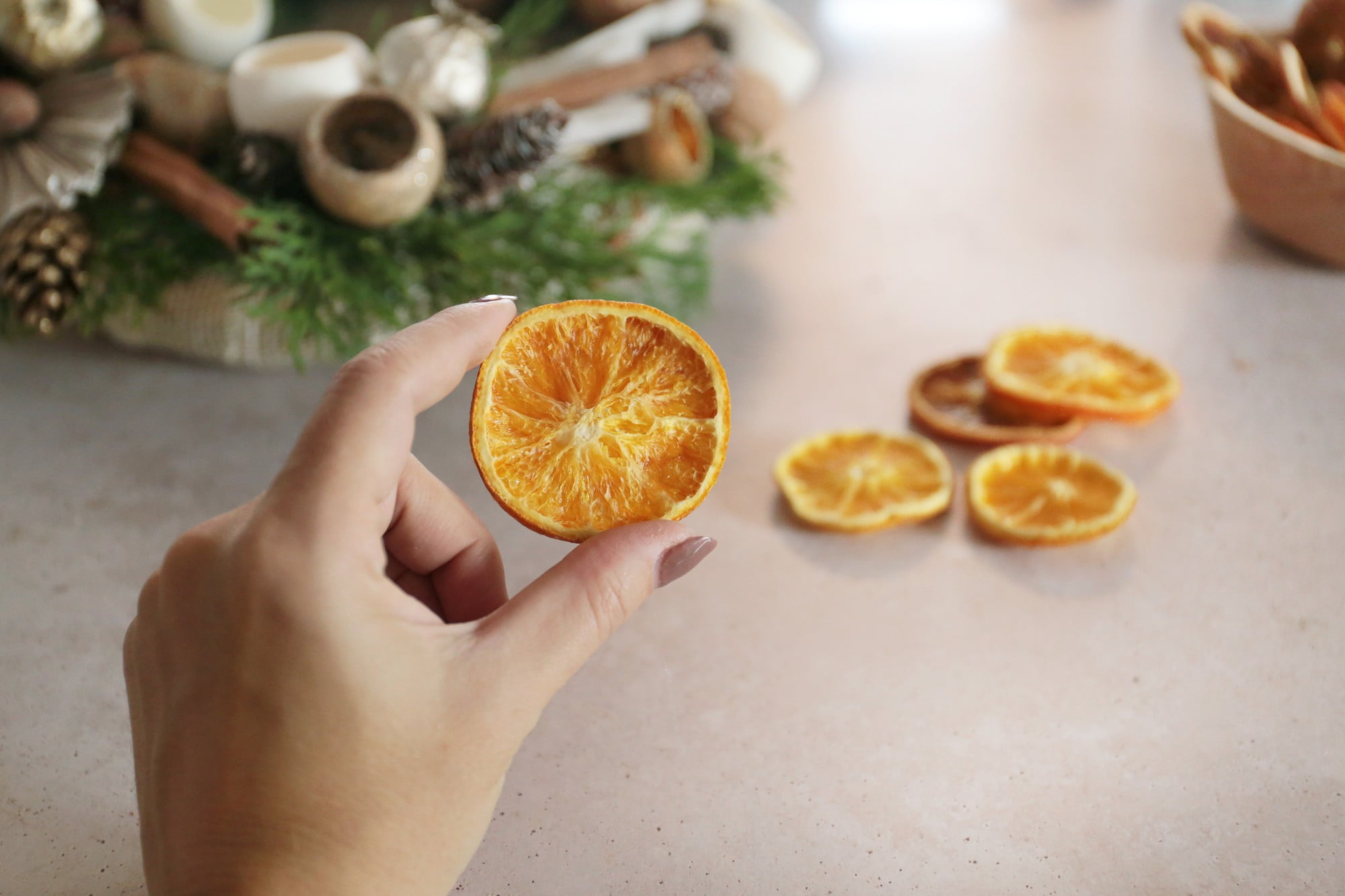 4. Pridėkite pušies spurgų, cinamono lazdelių ir džiovintų apelsinų griežinėlių