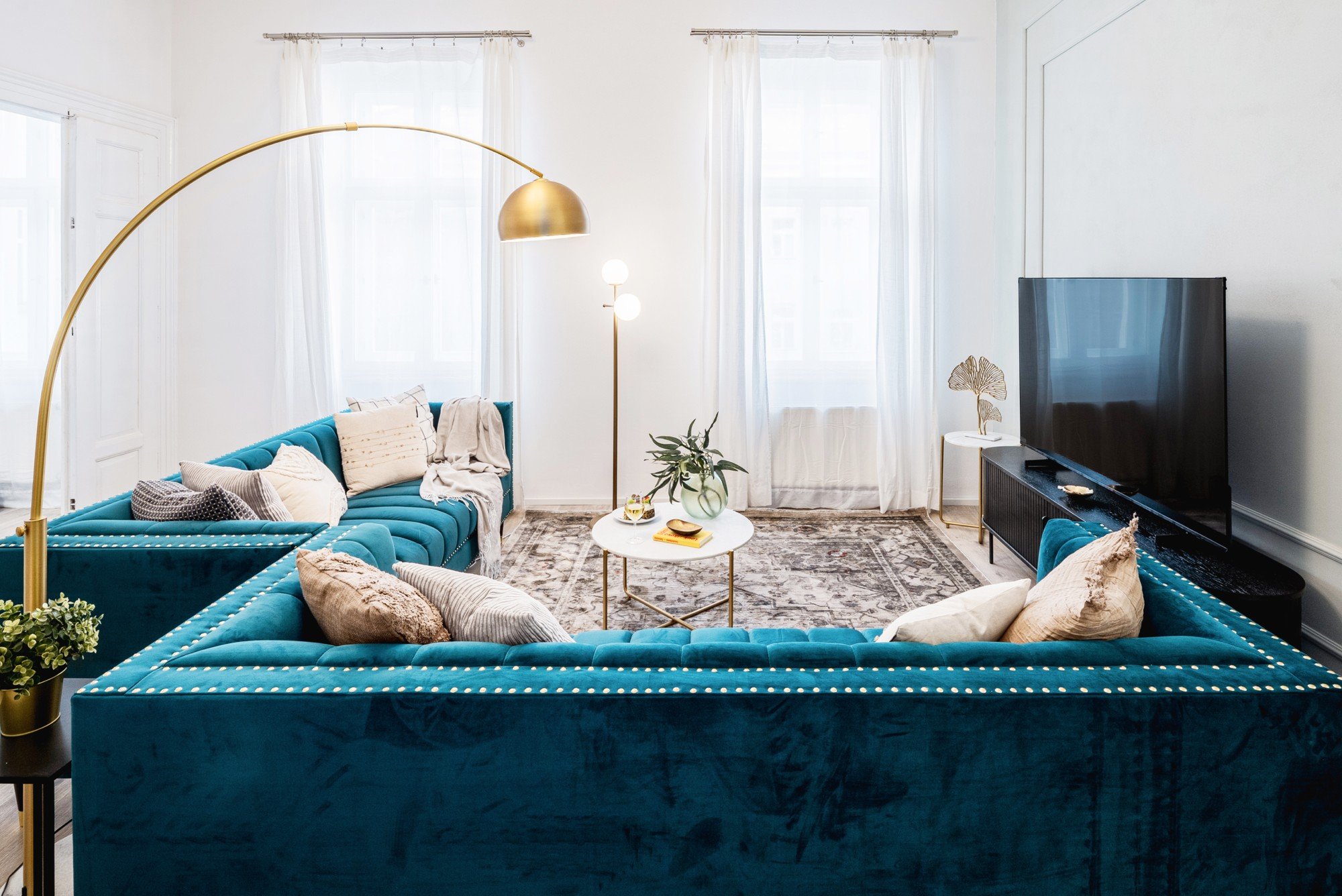 Auksiniai akcentai ir kruopščiai parinkti aksesuarai suteikia interjerui subtilaus žavesio. Rezultatas – reprezentatyvi, jauki ir kasdieniam naudojimui maloni svetainė.